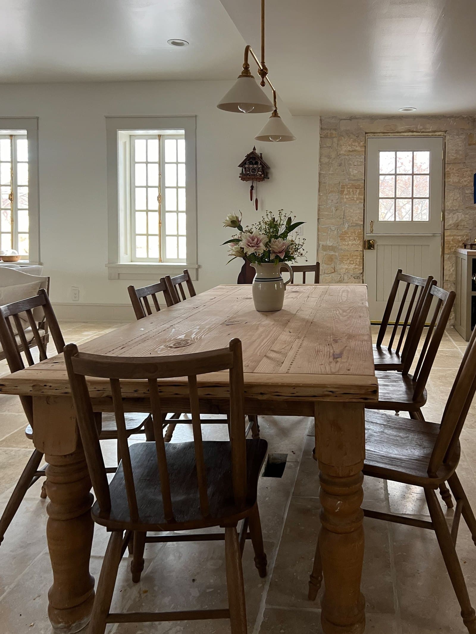 Long dining table beneath tall windows