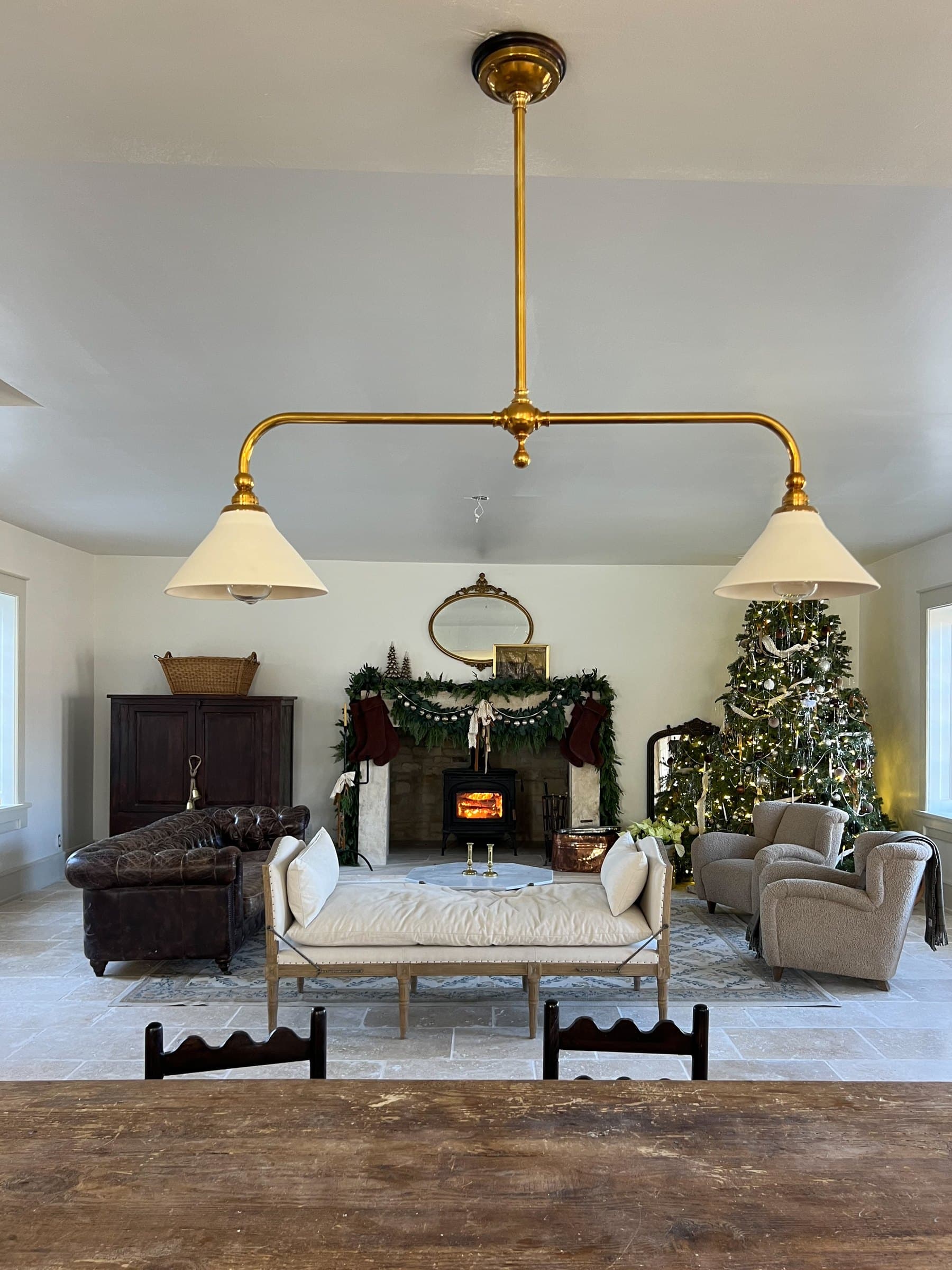 Great room with brass pendants over a stone floor